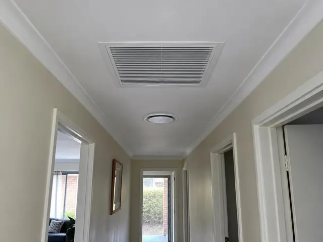 Ceiling return-air grille in a narrow hallway with cream walls and white trim in Elizabeth Downs